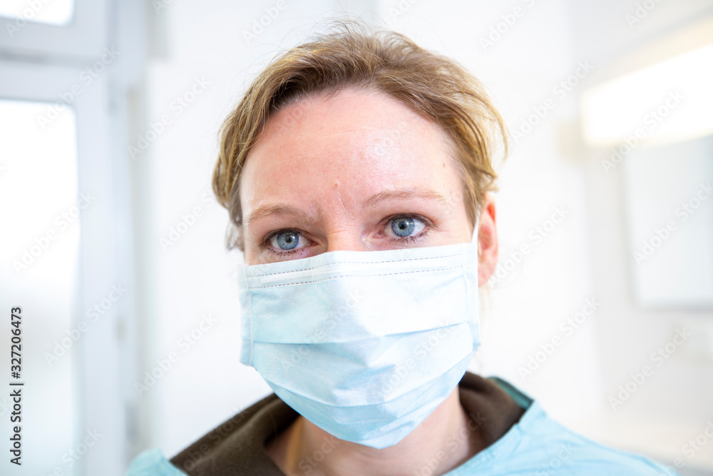 Female doctor in full protected medical suit holds a mouthpiece Female doctor in full protected medical suit holds a mouthpiece