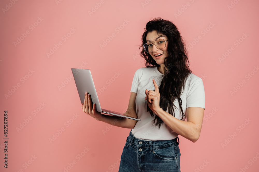 Portrait of a cheerful young blonde girl sitting on a floor isolated over pink background, using laptop computer Portrait of a cheerful young blonde girl sitting on a floor isolated over pink background, using laptop computer