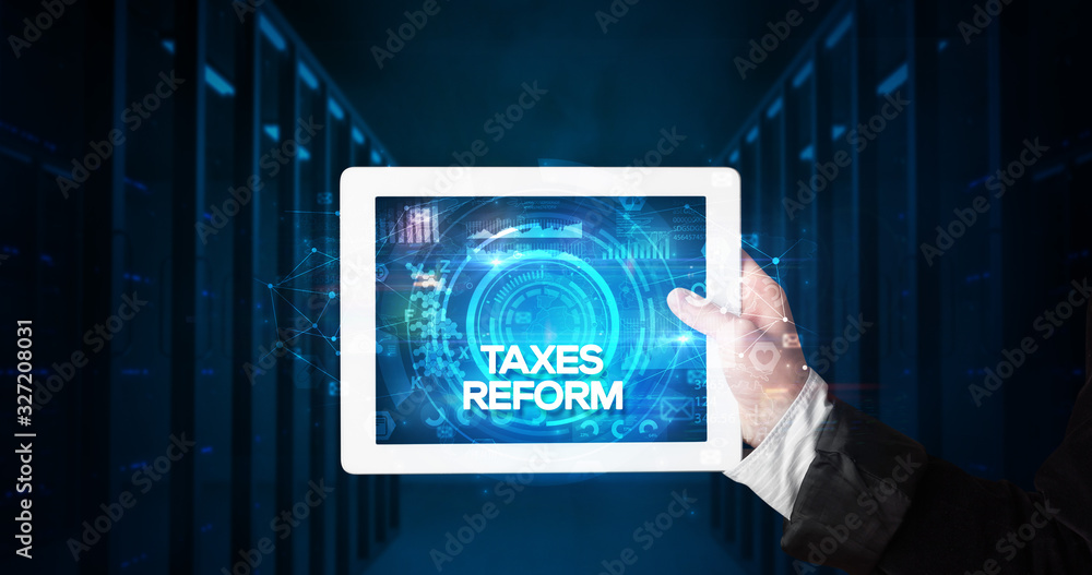 Young business person working on tablet and shows the inscription: TAXES REFORM, business concept Young business person working on tablet and shows the inscription: TAXES REFORM, business concept
