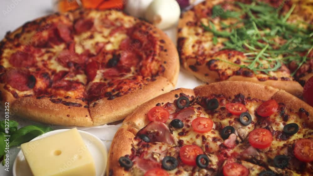 Three american style pizzas served on a table Three american style pizzas served on a table