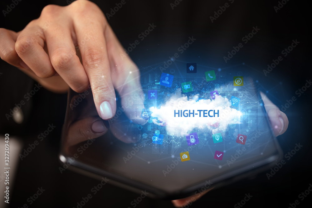 Businessman holding a foldable smartphone with HIGH-TECH inscription, technology concept Businessman holding a foldable smartphone with HIGH-TECH inscription, technology concept