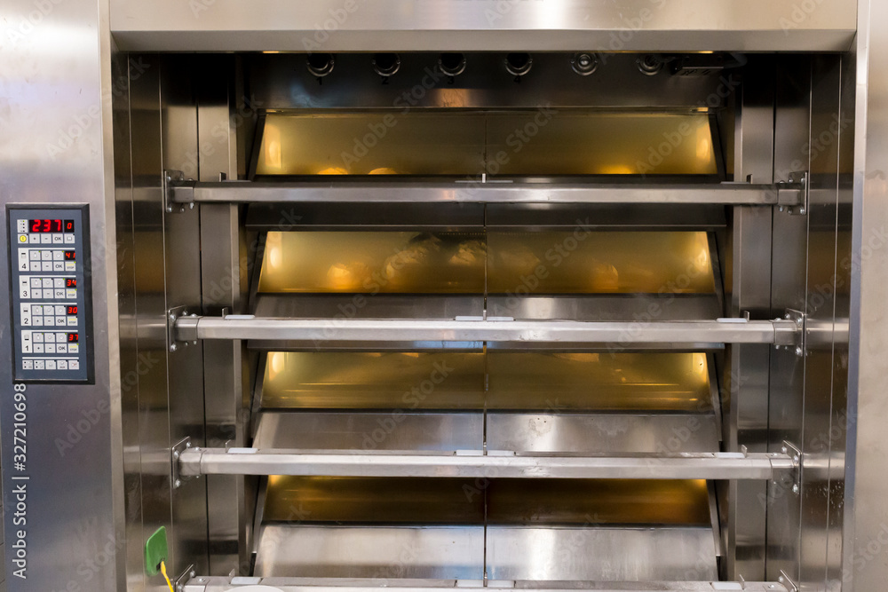 Working industrial bakery oven, with bread loafs inside