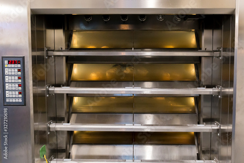 Working industrial bakery oven, with bread loafs inside