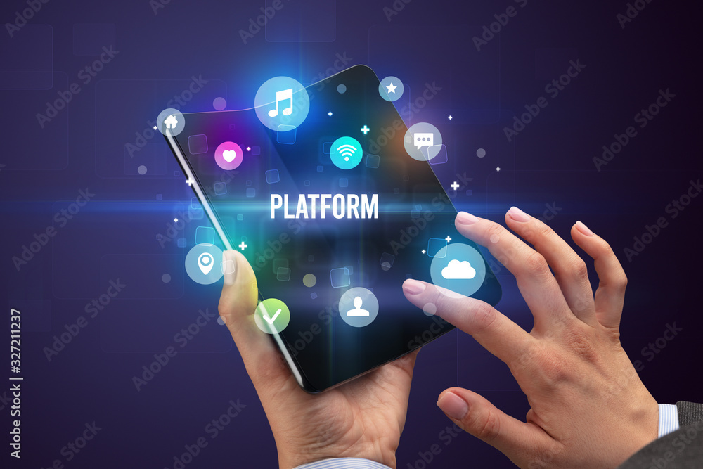 Fototapeta premium Businessman holding a foldable smartphone with PLATFORM inscription, social media concept