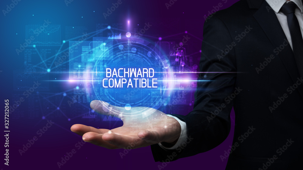Man hand holding BACKWARD COMPATIBLE inscription, technology concept Man hand holding BACKWARD COMPATIBLE inscription, technology concept