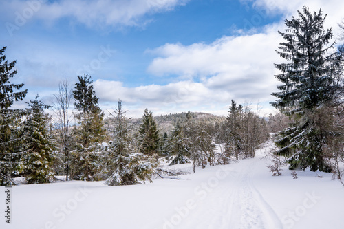 Fototapeta Naklejka Na Ścianę i Meble -  road in winter mountains rides cars and snow scooters, beautiful blue sky, slovakia beskidy, beskid mountains