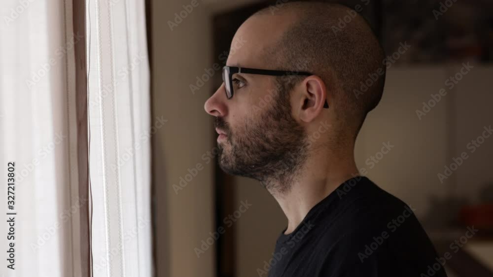 Anxious man thinks in front of the window. Face depressed of caucasian man Anxious man thinks in front of the window. Face depressed of caucasian man