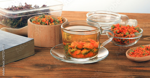 A cup of tea from dried marigold flowers on a wooden table on a white background.Make up.