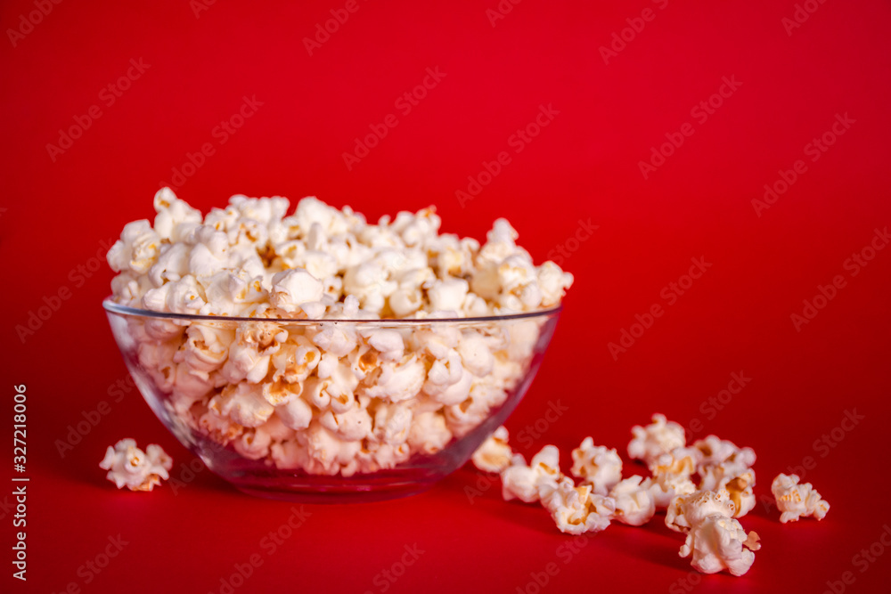 Delicious fresh popcorn in a bowl on red background Delicious fresh popcorn in a bowl on red background