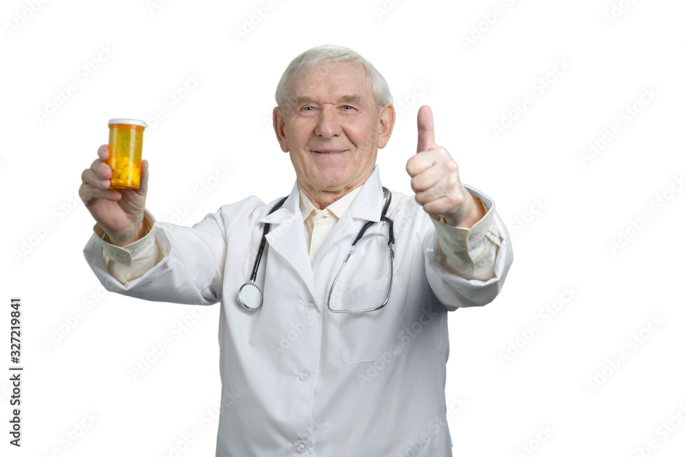 Senior doctor with painkillers and thumb up. Portrait of old pharmacist advertising pills. Senior doctor with painkillers and thumb up. Portrait of old pharmacist advertising pills.