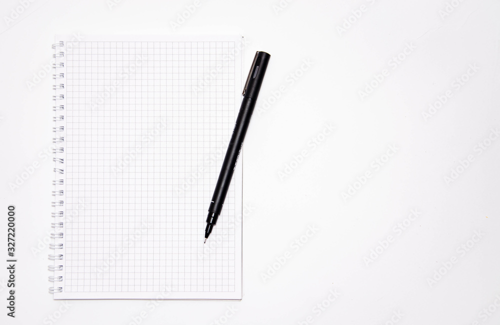 Squared notebook with black pen on a white background. Record ideas, notes, plans, tasks. Notebook top and side view. Flatlay. Copy Space Squared notebook with black pen on a white background. Record ideas, notes, plans, tasks. Notebook top and side view. Flatlay. Copy Space