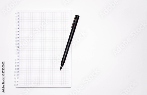 Squared notebook with black pen on a white background. Record ideas, notes, plans, tasks.  Notebook top and side view. Flatlay. Copy Space