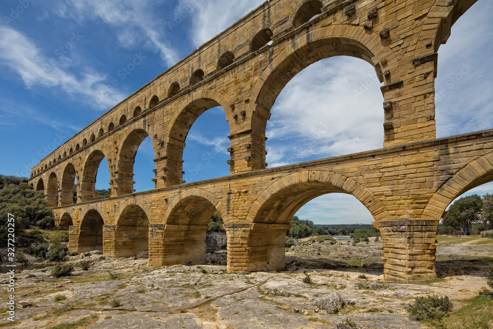 Pont du Gard is one of the most impressive samples of Roman architecture. Scenic view of ancient Roman aqueduct Pont du Gard  over Gardon river near Nimes, Gard, Provence, France