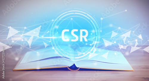 Open book with CSR abbreviation, modern technology concept