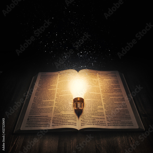 Fototapeta Light bulb lighting up an open bible
