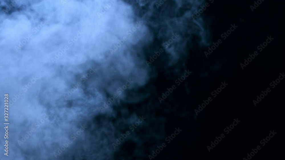 Blue cold colorful dense smoke coming from the left side in a black night background. Ice smoke cloud from factories. Vapor steam ascending in the dusk. Shot in 6k. Blue cold colorful dense smoke coming from the left side in a black night background. Ice smoke cloud from factories. Vapor steam ascending in the dusk. Shot in 6k.