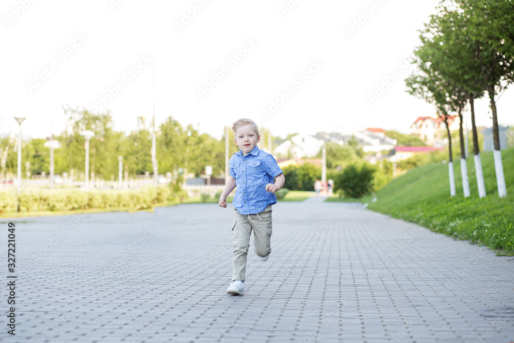 Child boy runs fast through the park. The concept is back to school, care and play. Child boy runs fast through the park. The concept is back to school, care and play.