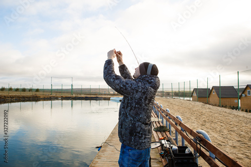 The fisherman catches the fish by net from the lake. Devices for fishing in fresh water photo