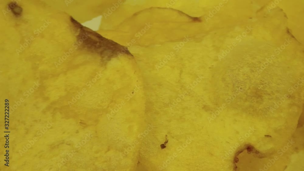 Yellow potato chips rotate in a plate Yellow potato chips rotate in a plate