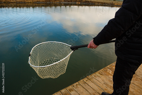Foto The fisherman catches the fish by net from the lake