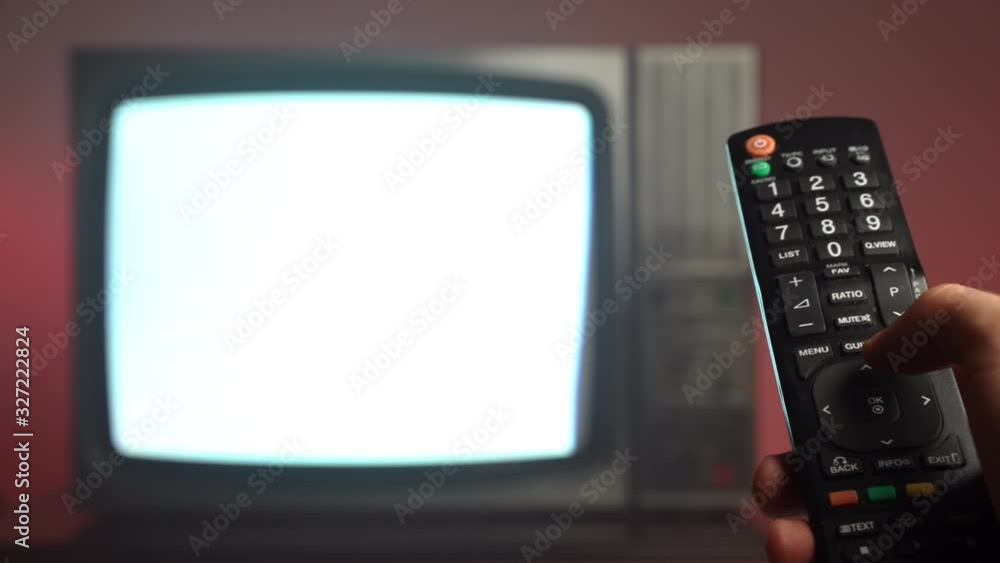 Closeup of man's hand holding vintage TV remote control and pushing