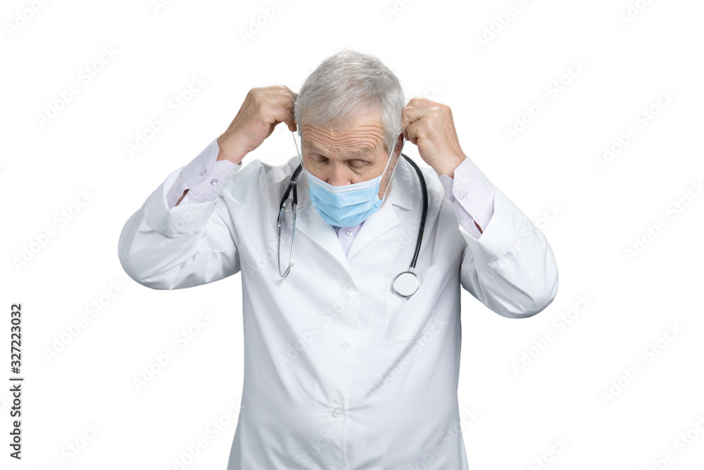 Old doctor put on medical mask. Physicial wearing protective mask. White isolated background. Old doctor put on medical mask. Physicial wearing protective mask. White isolated background.