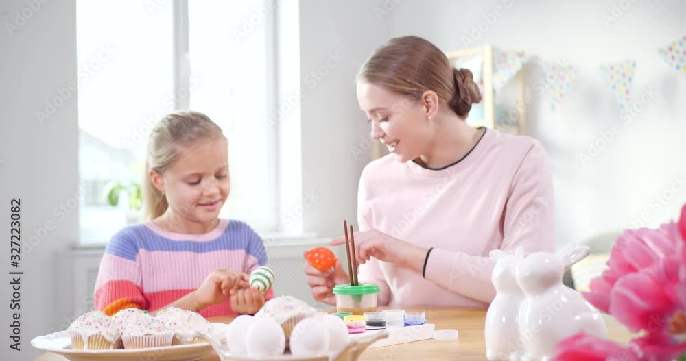 Happy mother and daughter with painted Easter eggs at home Happy mother and daughter with painted Easter eggs at home
