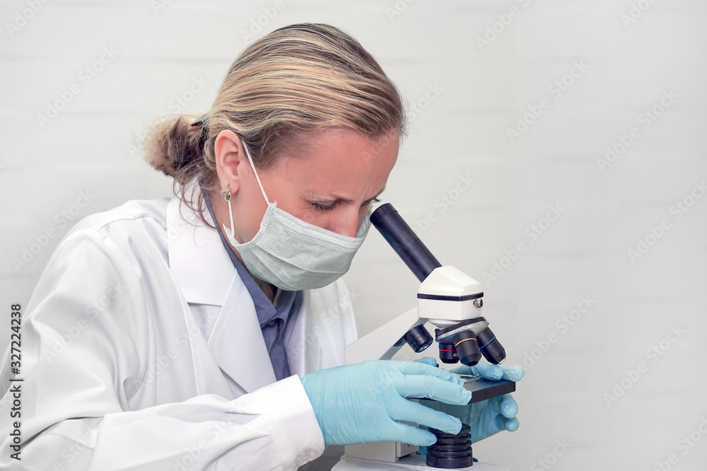 Female biochemist mixing substances to study under the microscope. Science student looking through microscope in the lab at the university. Technician in the laboratory using a microscope. Female biochemist mixing substances to study under the microscope. Science student looking through microscope in the lab at the university. Technician in the laboratory using a microscope.