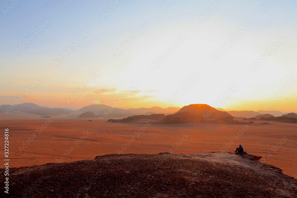 silhouette of man on top of the mountain at sunset  on the Wadi Rum red desert in Jordan