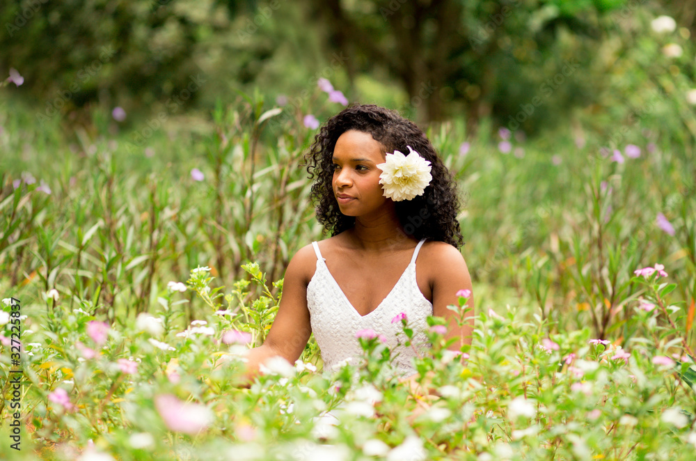 Contact with nature. Beautiful young black woman with curly hair in a flower field. Flower in hair. Contact with nature. Beautiful young black woman with curly hair in a flower field. Flower in hair.