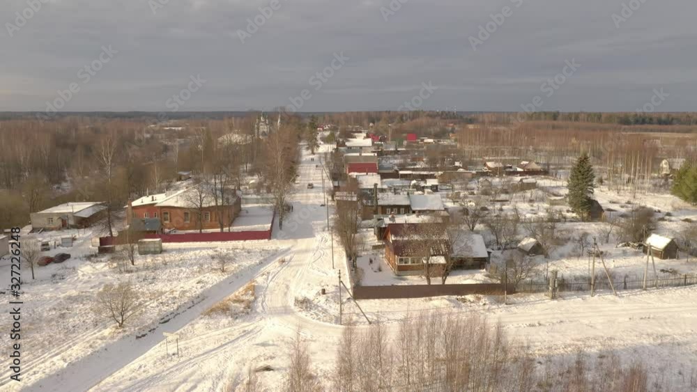 Aerial view of a Russian village. Panorama over the forest, houses. Sunny day. Traditional view of the Russian province, winter, snow, dullness, gloom. Aerial view of a Russian village. Panorama over the forest, houses. Sunny day. Traditional view of the Russian province, winter, snow, dullness, gloom.