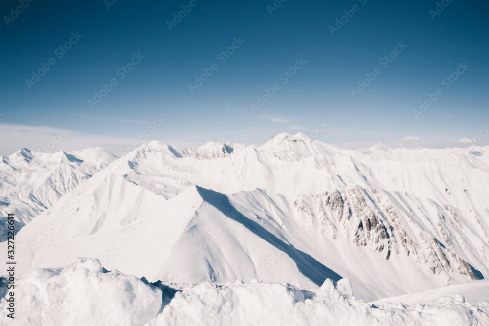 Snowy mountains in nice sun day. Caucasus Mountains, Georgia. View from ski resort Gudauri.