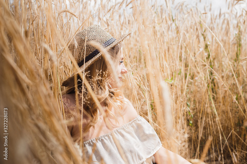 girl in a hat in a wheat field in summer