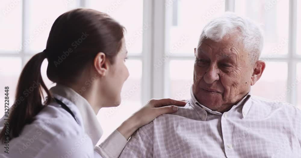 Smiling healthy senior grandpa talk to caring young female doctor Smiling healthy senior grandpa talk to caring young female doctor