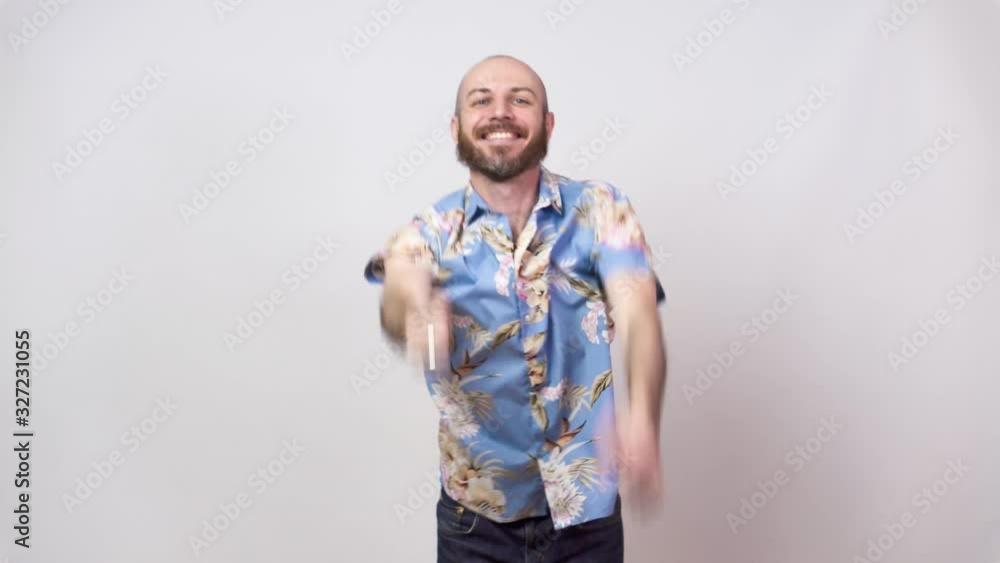 Funny dance of a man wearing hawaiian shirt. Cheerful bearded bald man dancing and having fun on white background. Funny dance of a man wearing hawaiian shirt. Cheerful bearded bald man dancing and having fun on white background.