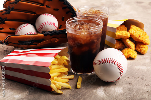 Chicken nuggets and french fries on the table with softdrink cola. Baseball party food with balls for the playoffs