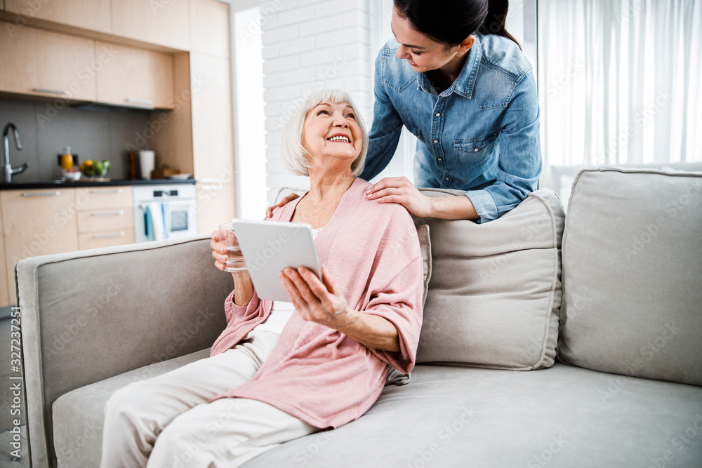 Cheerful old lady spending time with granddaughter at home Cheerful old lady spending time with granddaughter at home