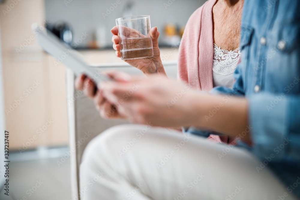 Obraz premium Old lady hand holding glass of water