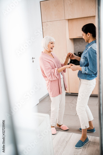 Grandmother and adult granddaughter having fun at home