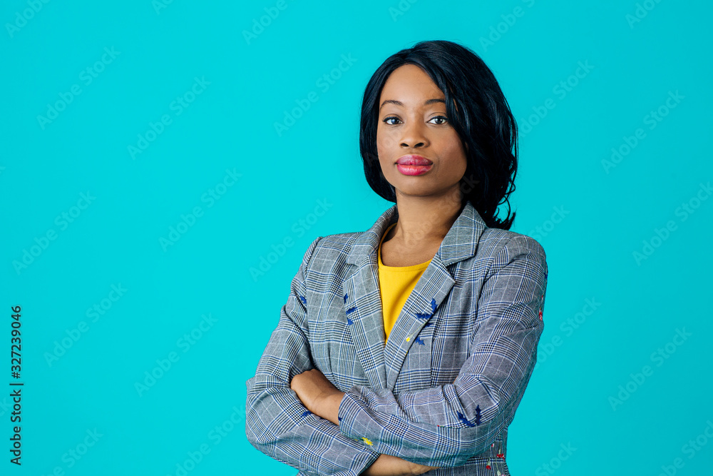 Portrait of a young woman in business jacket with arms crossed isolated on blue Portrait of a young woman in business jacket with arms crossed isolated on blue