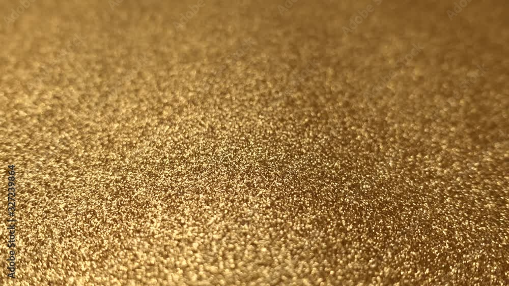 Camera panning very close to golden dust surface. Shallow depth of field, focus on foreground. Camera panning very close to golden dust surface. Shallow depth of field, focus on foreground.