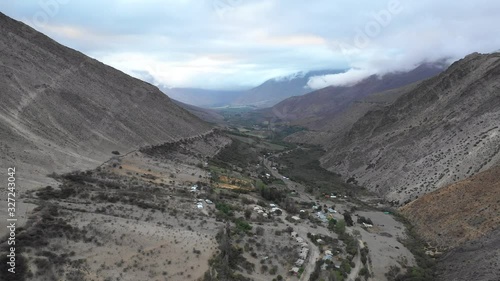 An aerial view inside Andes mountains at Limari Valley, south Atacama. An amazing wild scenery. Arid idyllic valleys with green farm fields feed in by the river at the bottom of the valley
 photo