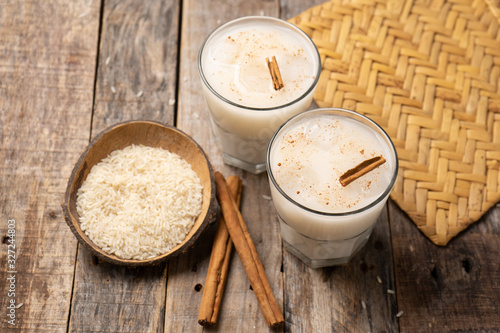 Mexican rice horchata with cinnamon on wooden background photo