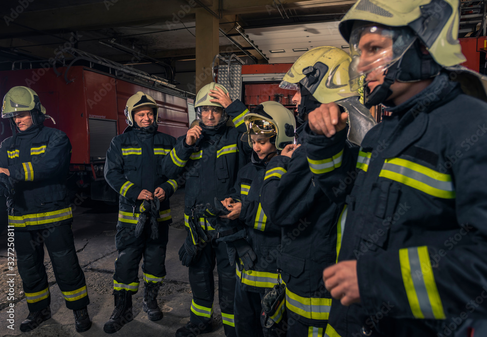Firemen preparing for emergency service. Firefighters putting on gloves. Firemen preparing for emergency service. Firefighters putting on gloves.