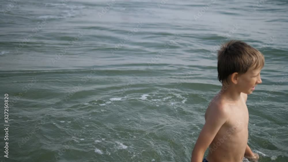 Boy play and jump in sea waves Boy play and jump in sea waves