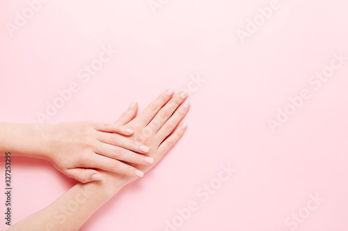 Woman s hands with beautiful manicure on pink background. Hands spa concept