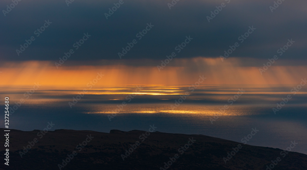 Fototapeta premium Crepuscular rays illuminating the sea off the Dorset coastline