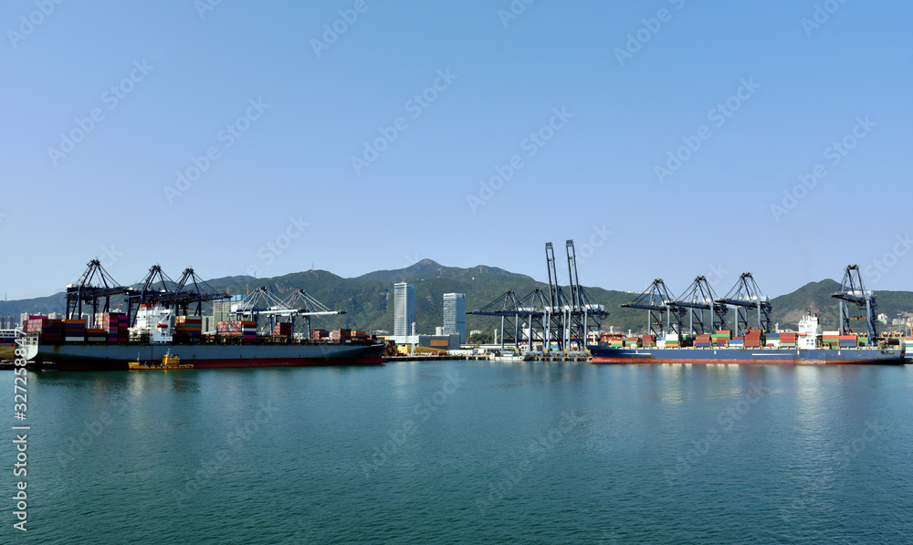 Panoramic view of the sea port with container terminal in Yantian, China. Ships are berthed under gantry cranes during cargo operation. 