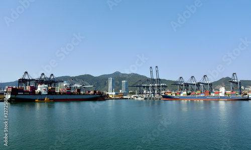 Panoramic view of the sea port with container terminal in Yantian  China. Ships are berthed under gantry cranes during cargo operation. 