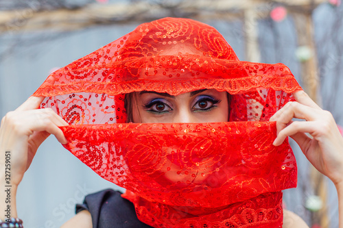 Fototapeta Naklejka Na Ścianę i Meble -  Beautiful eastern woman with makeup and jewelry wearing headscarf.